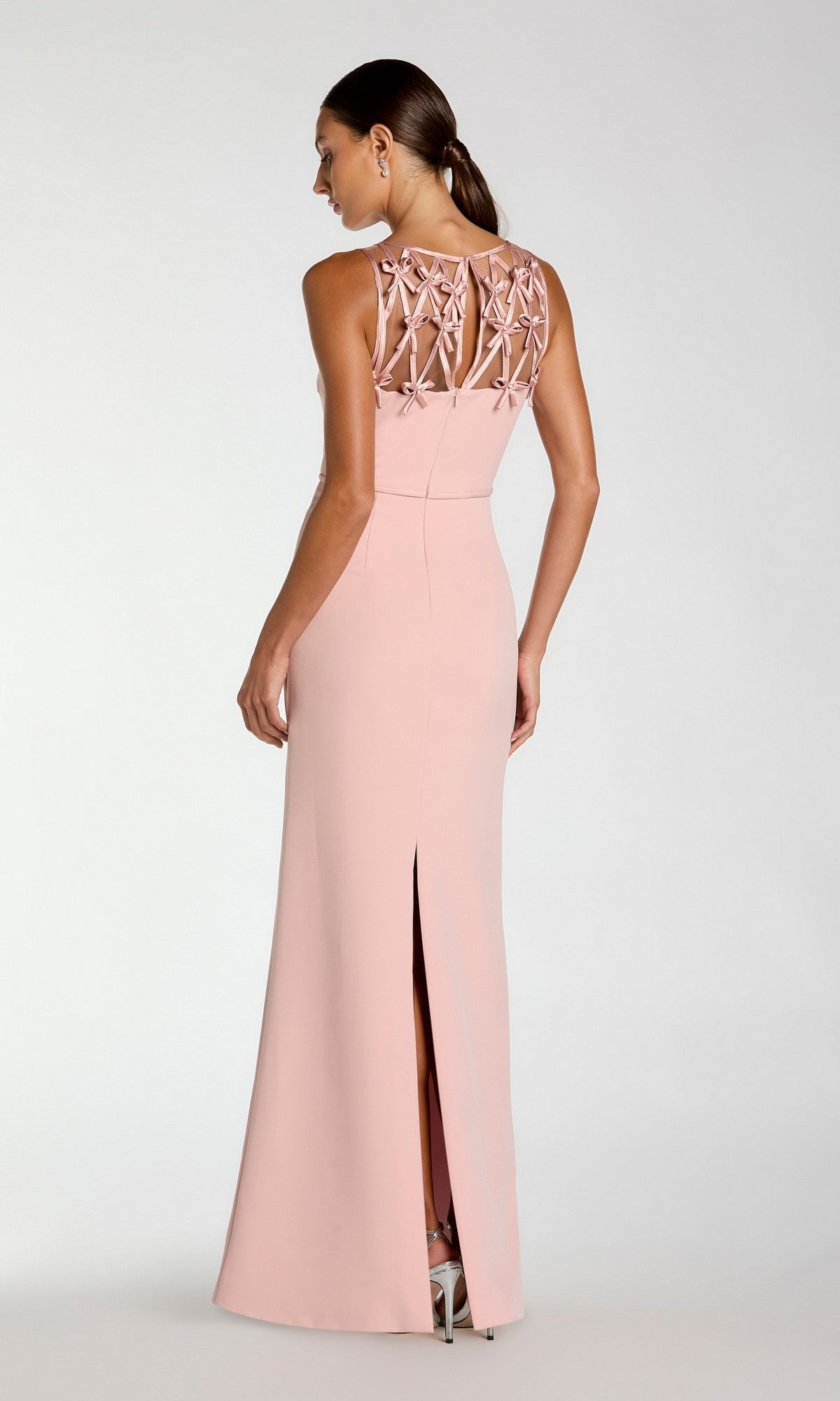 A woman stands against a plain background in the Mac Duggal 2295 Bow-Neck Long Black Formal Dress, featuring a floor-length silhouette and elegant bow-neck detail.